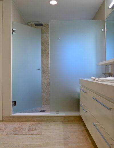 frosted glass doors on a shower stall oversized with rain shower head