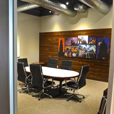 office space with industrial exposed vents and wood slat wall
