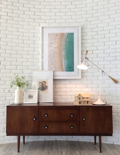 curved white brick wall with retro hutch and beachy decorations