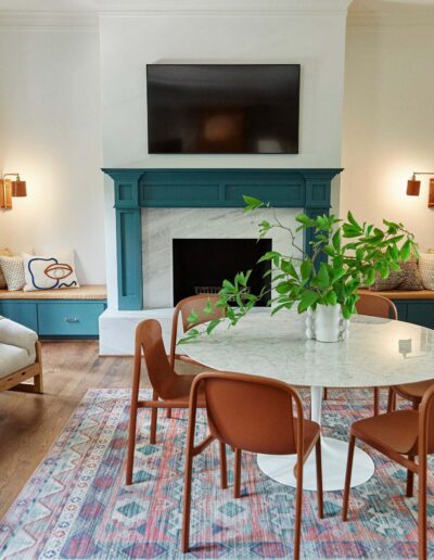 white room with a teal fireplace and built-in benches
