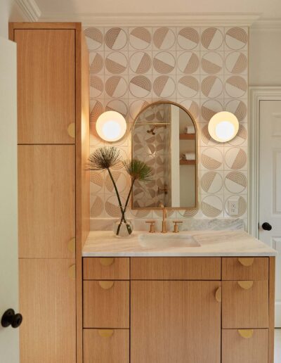 retro gold and wood vanity with geometric wallpaper and round wall sconces