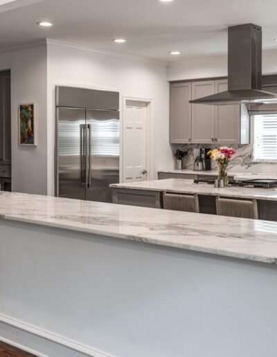 White kitchen with stainless steel appliances, large amounts of counter space, and stylish shaker cabinets
