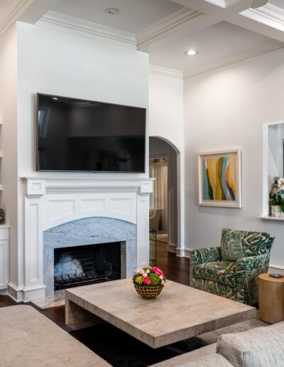 living room with built-in shelving and fireplace near the large kitchen