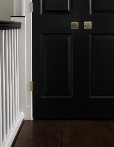 black French doors with brushed gold hardware near stairs
