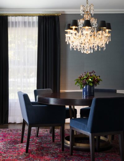 dining area with retro modern furnishings, crystal chandelier, and window dressed with black and sheer white curtains